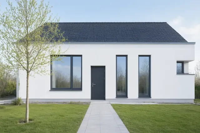 Modernes Einfamilienhaus mit weißer Fassade, Rasen und Gartenweg